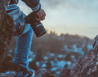 a person holding a camera againsst their leg with keys hanging from their pocket